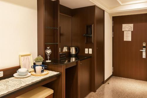 Una cocina con gabinetes marrones y una encimera con platos encima. en 丰居一中 Via Garden Hotel, en Taichung