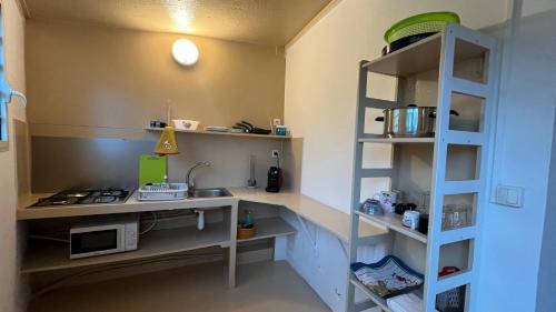 a small kitchen with a counter and a shelf at Beach Studio - 24h24 et 7j7 in Petite Île