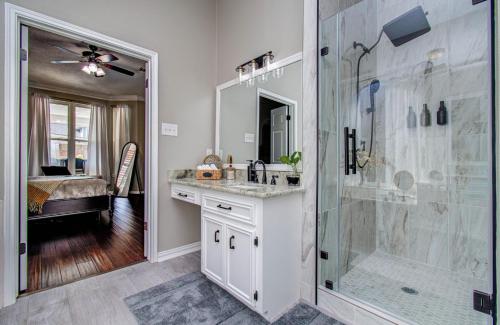 een badkamer met een inloopdouche, een wastafel en een spiegel bij Heated Pool • Hot Tub • Game Loft • 4BR in Atascocita