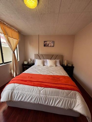 キトにあるDepa Guajaló - Quicentro Sur con Terraza y Parkingのベッドルーム1室(赤い毛布付きのベッド1台付)