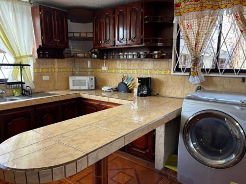 キトにあるDepa Guajaló - Quicentro Sur con Terraza y Parkingのキッチン(カウンター、洗濯機付)