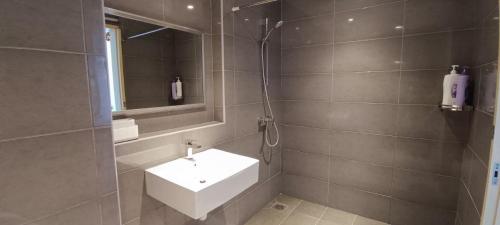 a bathroom with a white sink and a mirror at Kuantan Imperium seaview cityview by Avenzee in Kuantan