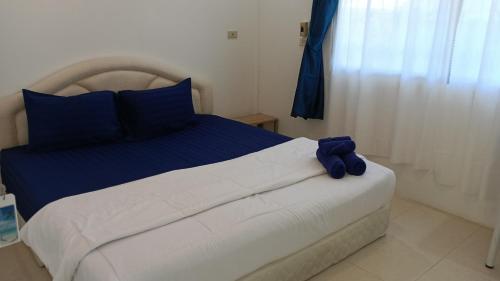 a bedroom with a bed with a blue stuffed animal on it at Sukkeehouse in Ko Larn