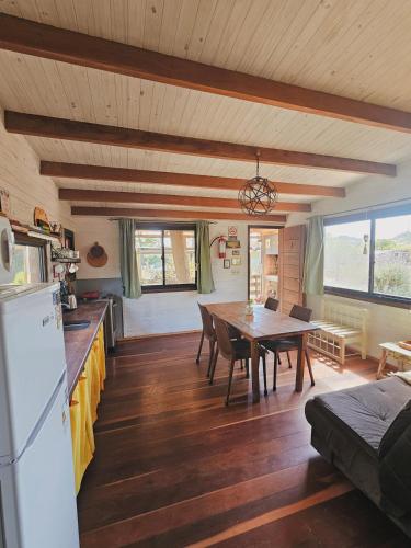 kuchnia i jadalnia ze stołem i lodówką w obiekcie DiaBro's w mieście Punta del Diablo