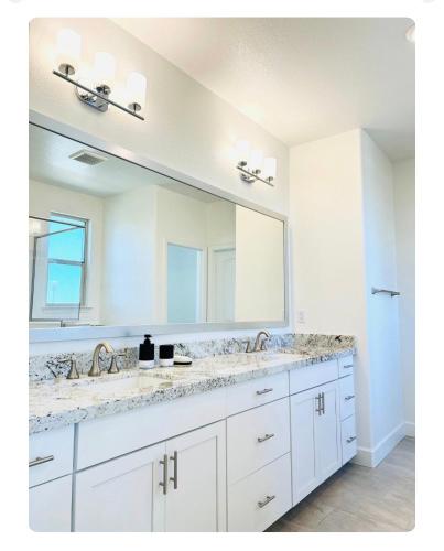 a bathroom with two sinks and a large mirror at Cozy Private master bedroom in a single family house in Elk Grove