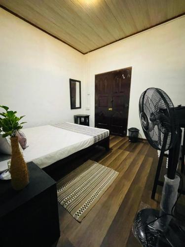 a room with a bed and a fan in it at Serene Garden Lodge in Ahangama