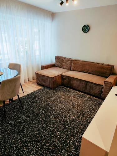 a living room with a couch and a table at Apartamentai šalia miesto centro in Telšiai
