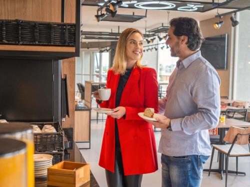 瓜拉普阿瓦ibis Guarapuava的男人和女人拿着一盘食物