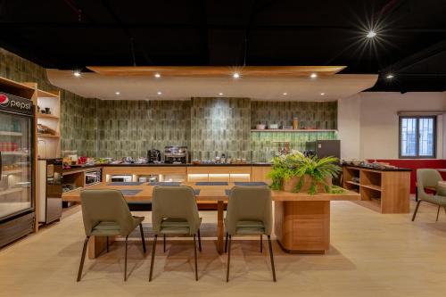 Tago Airport Hotel في مدينة هوشي منه: مطبخ مع طاولة وكراسي خشبية كبيرة