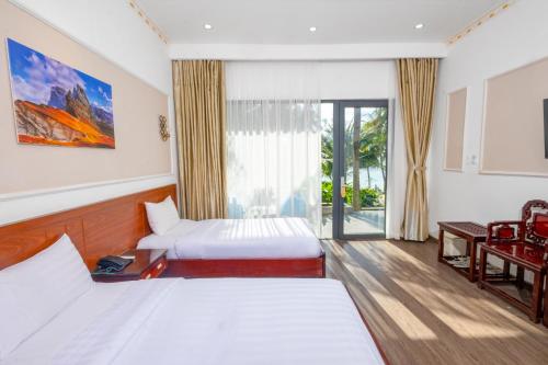 a hotel room with two beds and a balcony at Hawaii Resort Phu Quoc in Phu Quoc