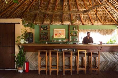 a man standing behind a bar in a restaurant at Puerto Dreams H in Puerto Escondido