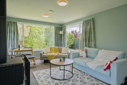 a living room with a blue couch and a table at Cotswold Retreat in Christchurch