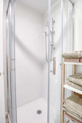 a shower with a glass door in a bathroom at Cotswold Retreat in Christchurch