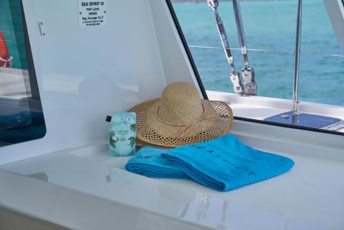 ein Strohhut und ein blaues Handtuch auf einem Boot in der Unterkunft Catamaran Liveaboard Charters Mauritius in Rivière Noire