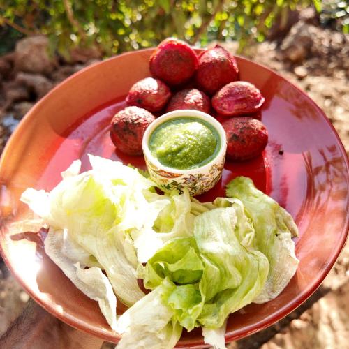 un piatto di cibo con lattuga e una ciotola di salsa verde di 360 Agonda ad Agonda