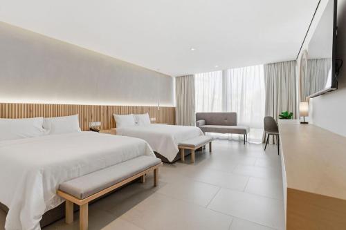a large hotel room with two beds and a chair at Hotel Alcalà Centro in Guadalajara
