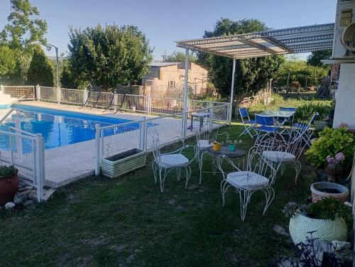 eine Terrasse mit Stühlen und einem Tisch neben einem Pool in der Unterkunft La Soñada in Villa Parque Siquiman