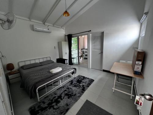 een slaapkamer met een bed, een tafel en een deur bij Koh Lipe Apartment in Satun