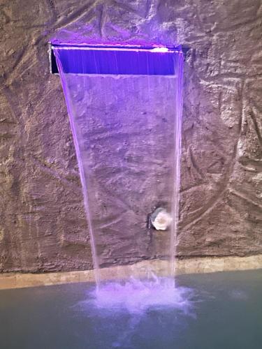a water fountain in a rock wall with purple water at Casa Emma fantástica con acceso a beach club ! in Holbox Island