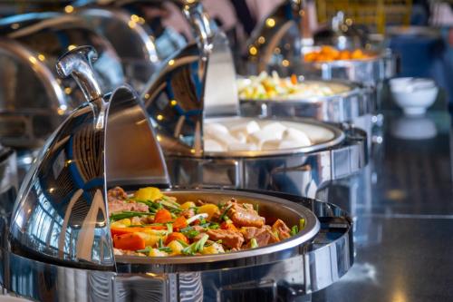 una fila di vassoi di cibo su una linea a buffet di Hawaii Resort Phu Quoc a Phu Quoc
