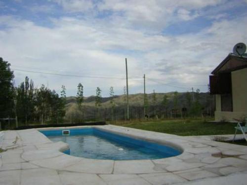 una pequeña piscina en un patio con una casa en Casa Montaña Valle del Sol en Potrerillos