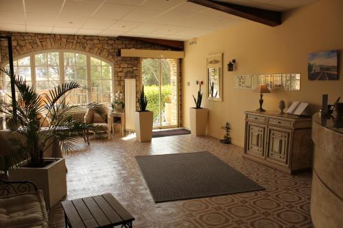 a living room with a couch and a table at Logis Hôtel Le Manoir & Lounge in Apt