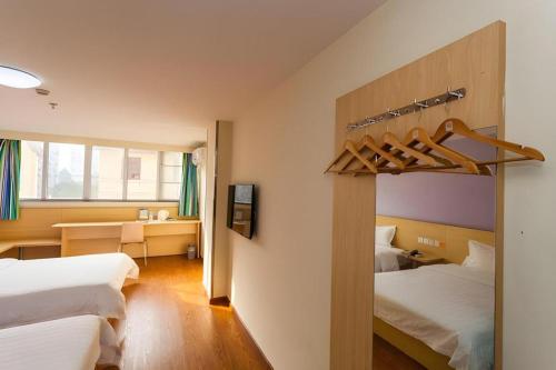 a hotel room with two beds and a desk at 7 Days Inn Chengdu North Railway Metro Station in Chengdu