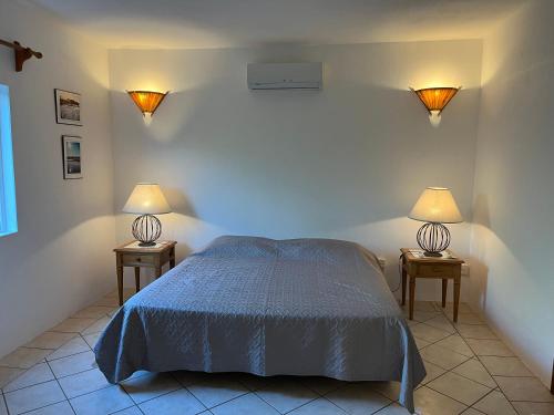 a bedroom with a bed and two lamps on two tables at Tropical Studio in Tamarin