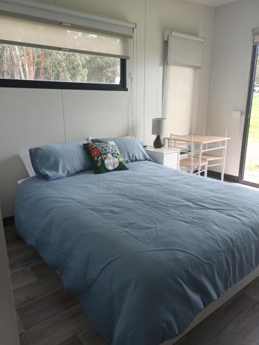 a large bed in a bedroom with a large window at Berry World in Timboon