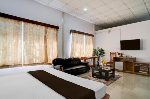 a bedroom with a bed and a couch and a tv at Palette Hotel And Resort Garikhana Shillong Formerly Council Lodge in Shillong