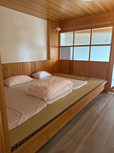 東港鎮にあるRoyal Court B&Bの窓のある部屋のベッド