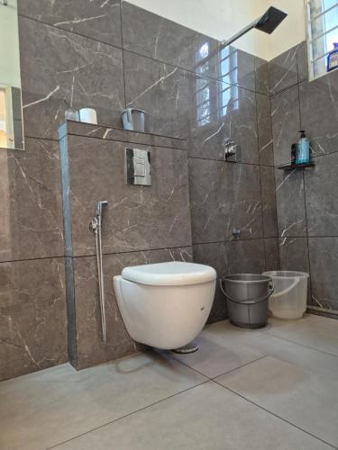 a bathroom with a toilet and a shower stall at Willow The Villas in Mananthavady