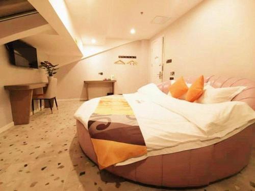 a large bed in the middle of a room at Shell Hotel Shanghai Jinshan Wanda Plaza in P'ai-ts'ang