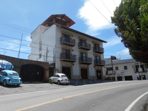 two old cars parked in front of a building at Hotel el Ángel Taxco in Taxco de Alarcón