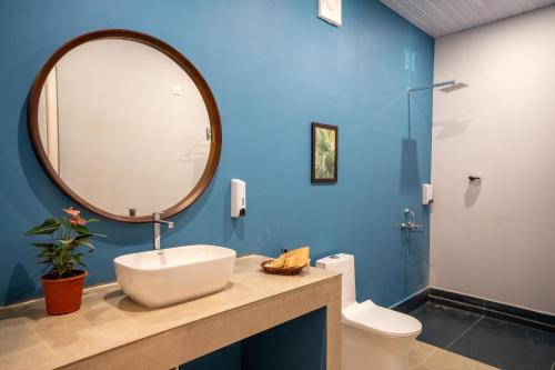 un bagno con lavandino, specchio e WC di Agonda Brown Sand ad Agonda