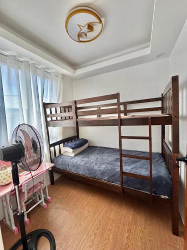 a bedroom with two bunk beds and a fan at Sofias Townhouse for Rent in Dasmariñas