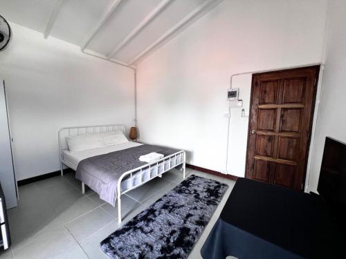 een slaapkamer met een bed en een houten deur bij Koh Lipe Apartment in Satun