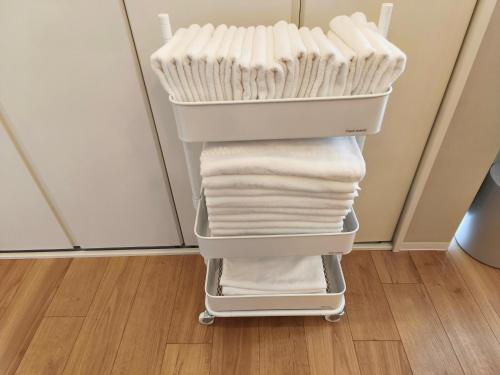 a cart filled with white towels in a room at Nishiki Stay Takamatsu101 in Takamatsu