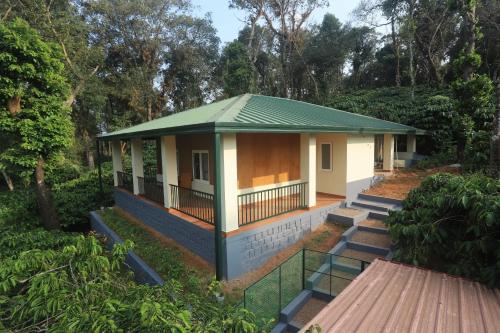 a small house with a green roof at Coffee Courtyard in Kurchi