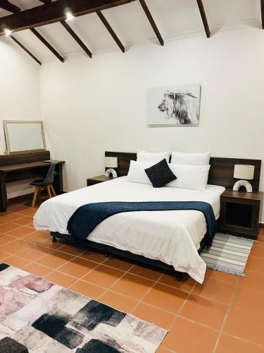a bedroom with a large bed and a piano at Alwande's Guesthouse in Richards Bay