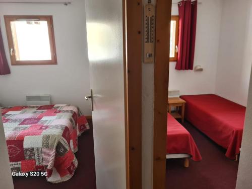 una piccola camera da letto con un letto e una finestra di T3 Les Cristallines a Orcières