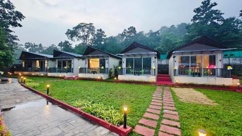 Mountain Woods Farmstay, Khopoli Pure Veg في خوبولي: صف من البيوت مع اضواء في ساحة