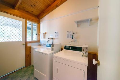 a small laundry room with a washer and dryer at Awonga Cottages in Halls Gap