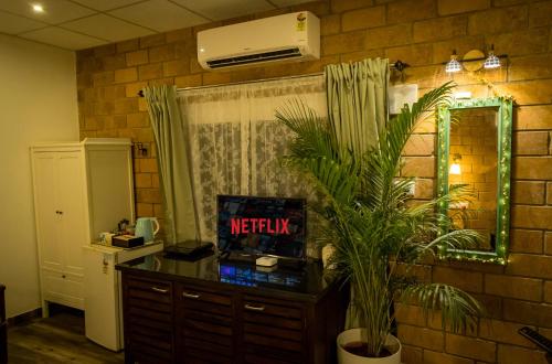 Cette chambre comprend un bureau, un miroir et une plante. dans l'établissement Happy Haven Farmstay, à Mangalore