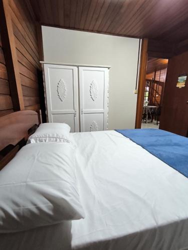 Cantinho do Sonho - Chalé Areia في باليوسا: غرفة نوم بسرير كبير مع ملاءات بيضاء