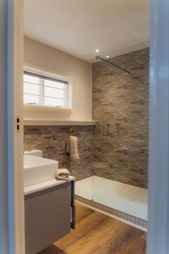 a bathroom with a sink and a shower at Fabella Serenety Flat in Muizenberg