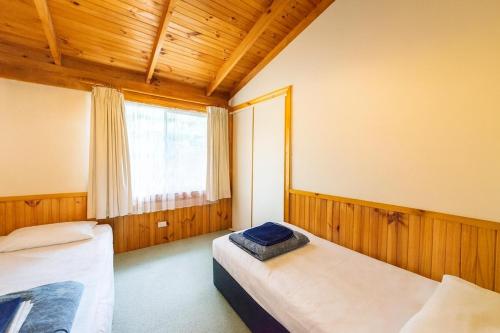 a bedroom with two beds and a window at Awonga Cottages in Halls Gap