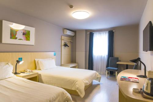 um quarto de hotel com duas camas e uma janela em Jingjiang Inn Hefei Hi-tech Park West Changjiang Road em Hefei