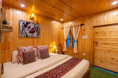 a bedroom with a bed in a wooden room at Himtrek Stays Katagala in Kasol