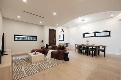 una sala de estar con un sofá y una mesa en Luxe 3-bedroom Townhouse in Miranda underground parking, en Miranda